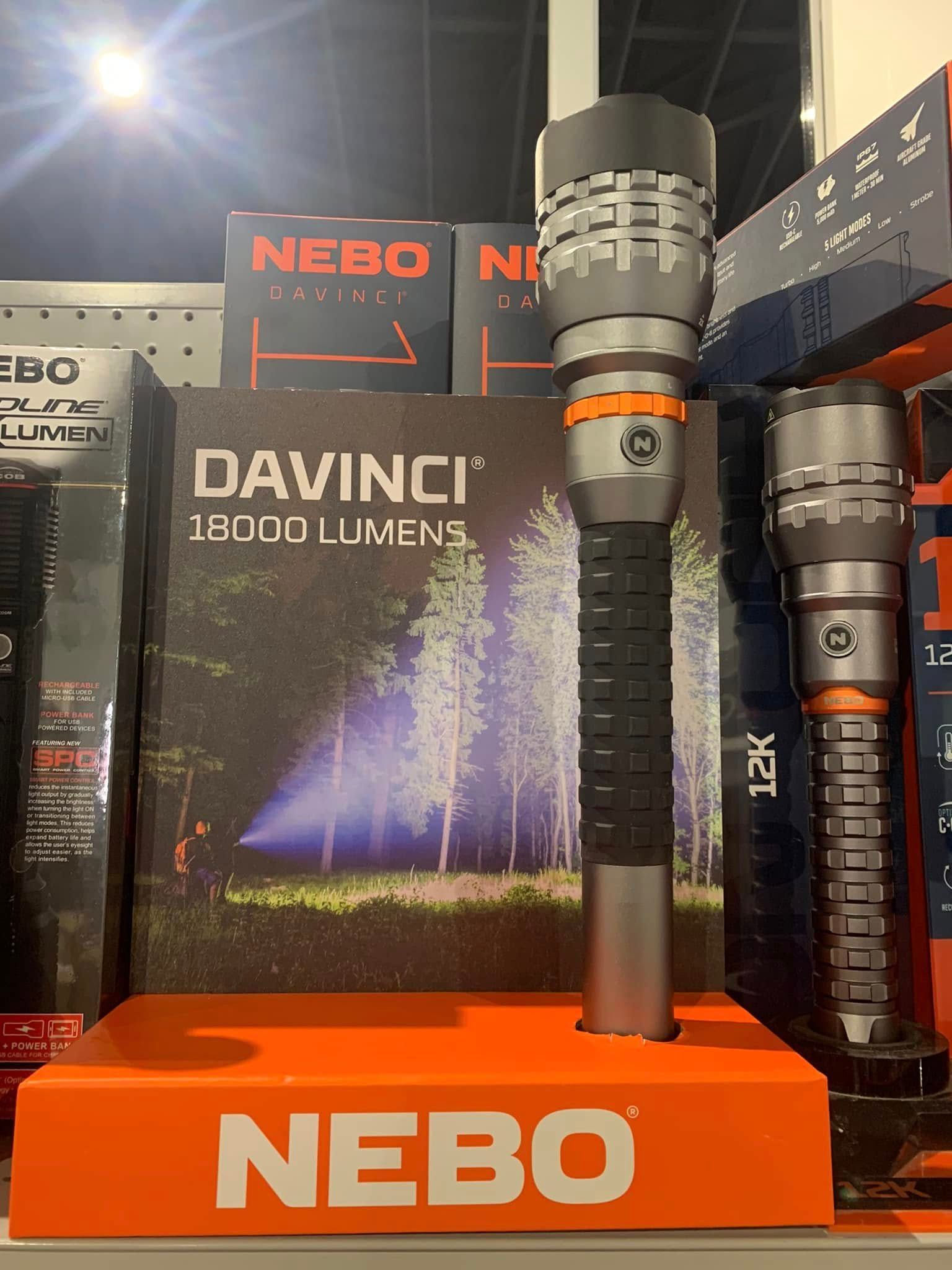 NEBO DaVinci flashlight display with black and orange flashlights on an orange stand.