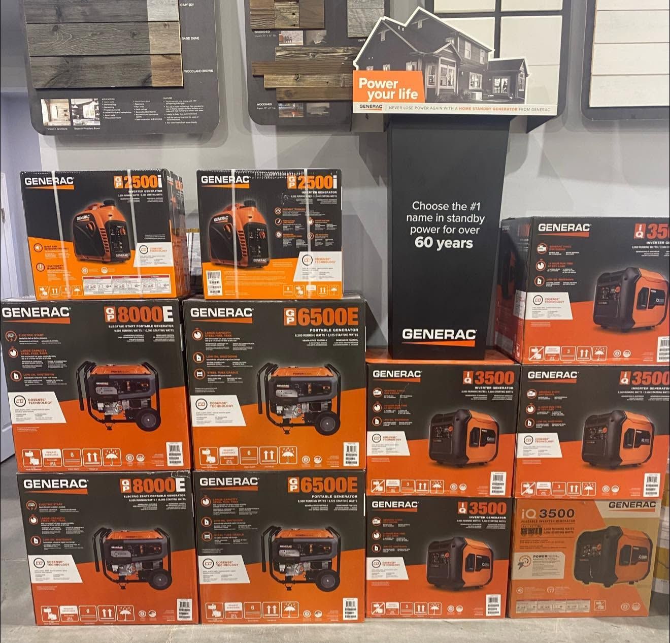 Stacked orange-and-black Generac generator boxes displayed on store shelves.