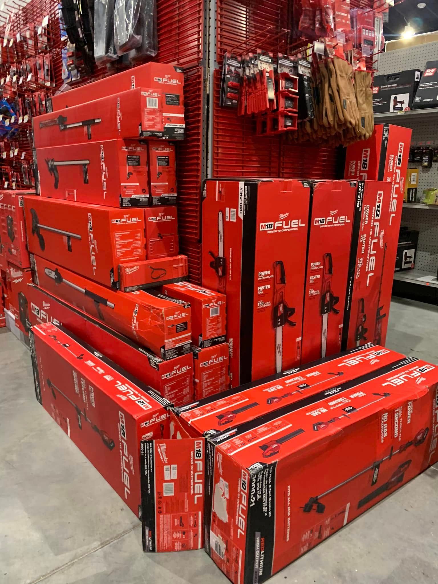 Stacks of red Milwaukee toolboxes and cases on a store floor display.
