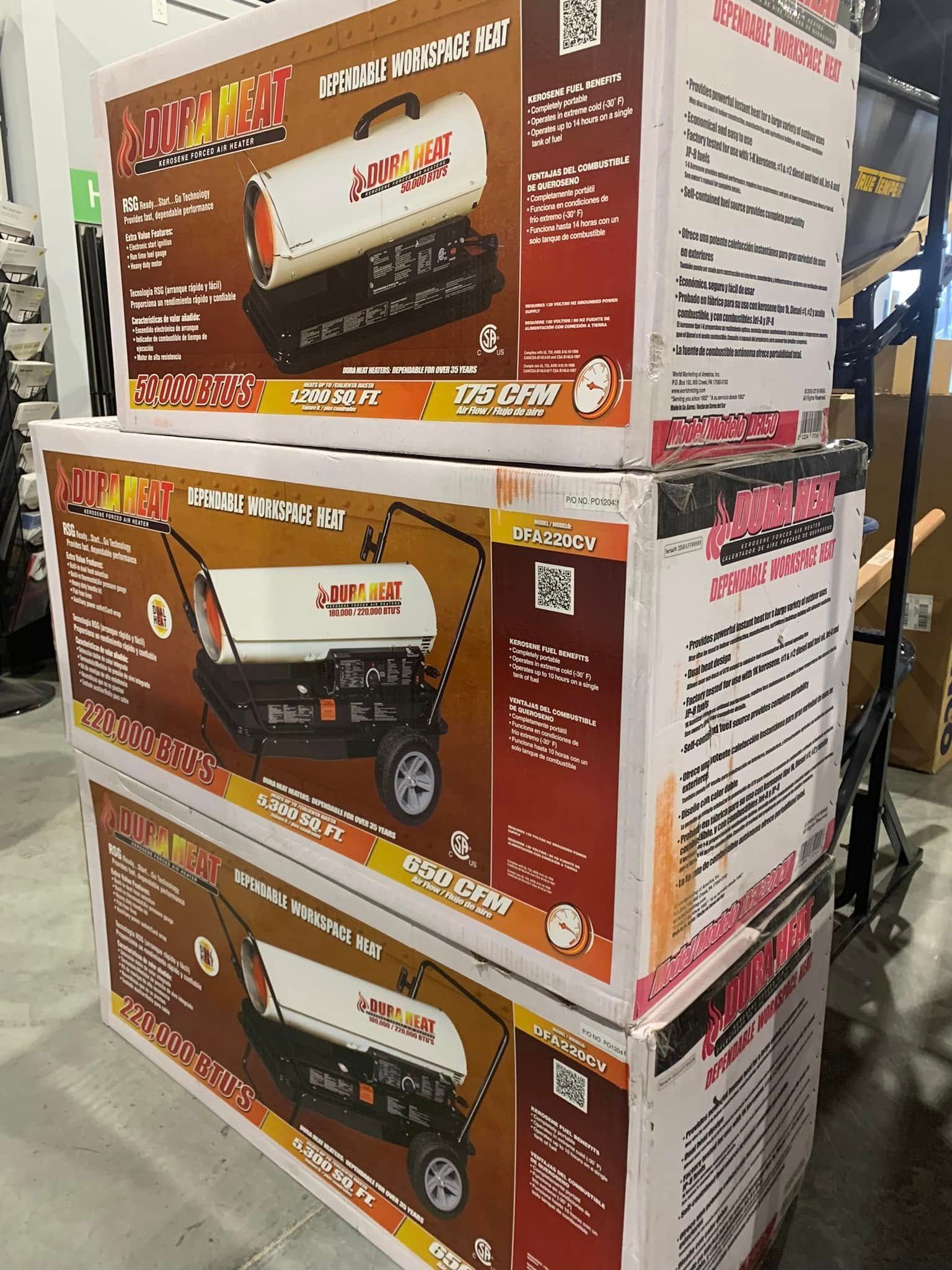 Stacked boxed grill carts in a store aisle, with brown and white packaging and product photos.