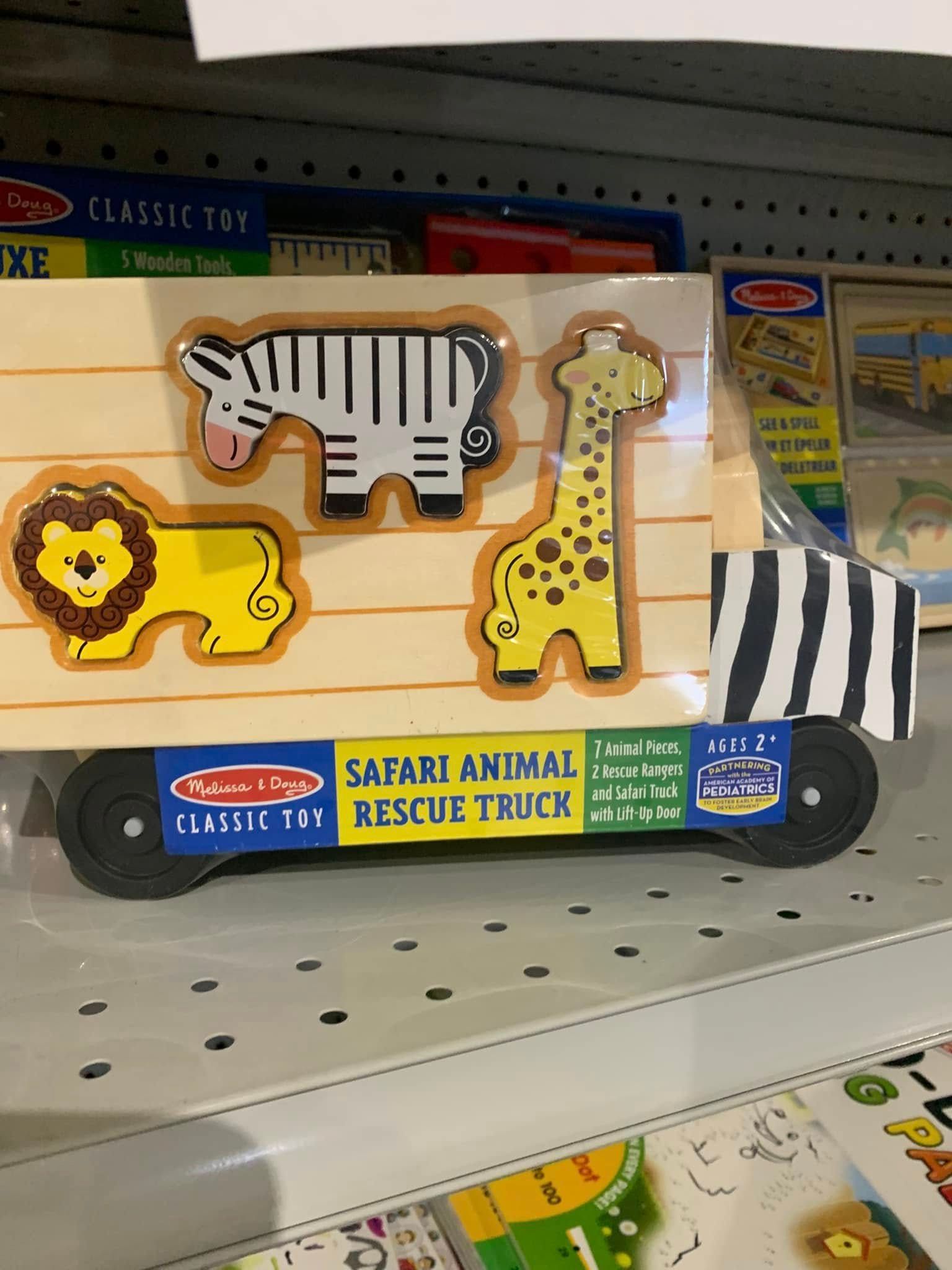 Safari animal rescue truck toy with zebra, giraffe, lion, and striped truck on store shelf