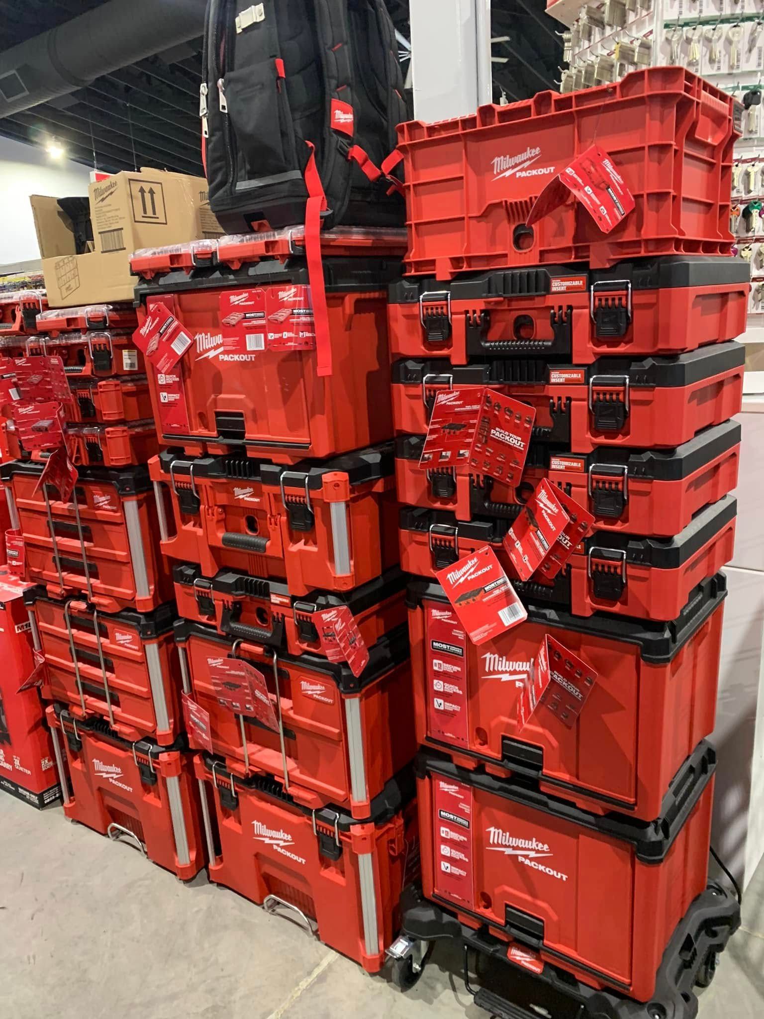 Stacked red plastic crates in a warehouse aisle, piled high on pallets.
