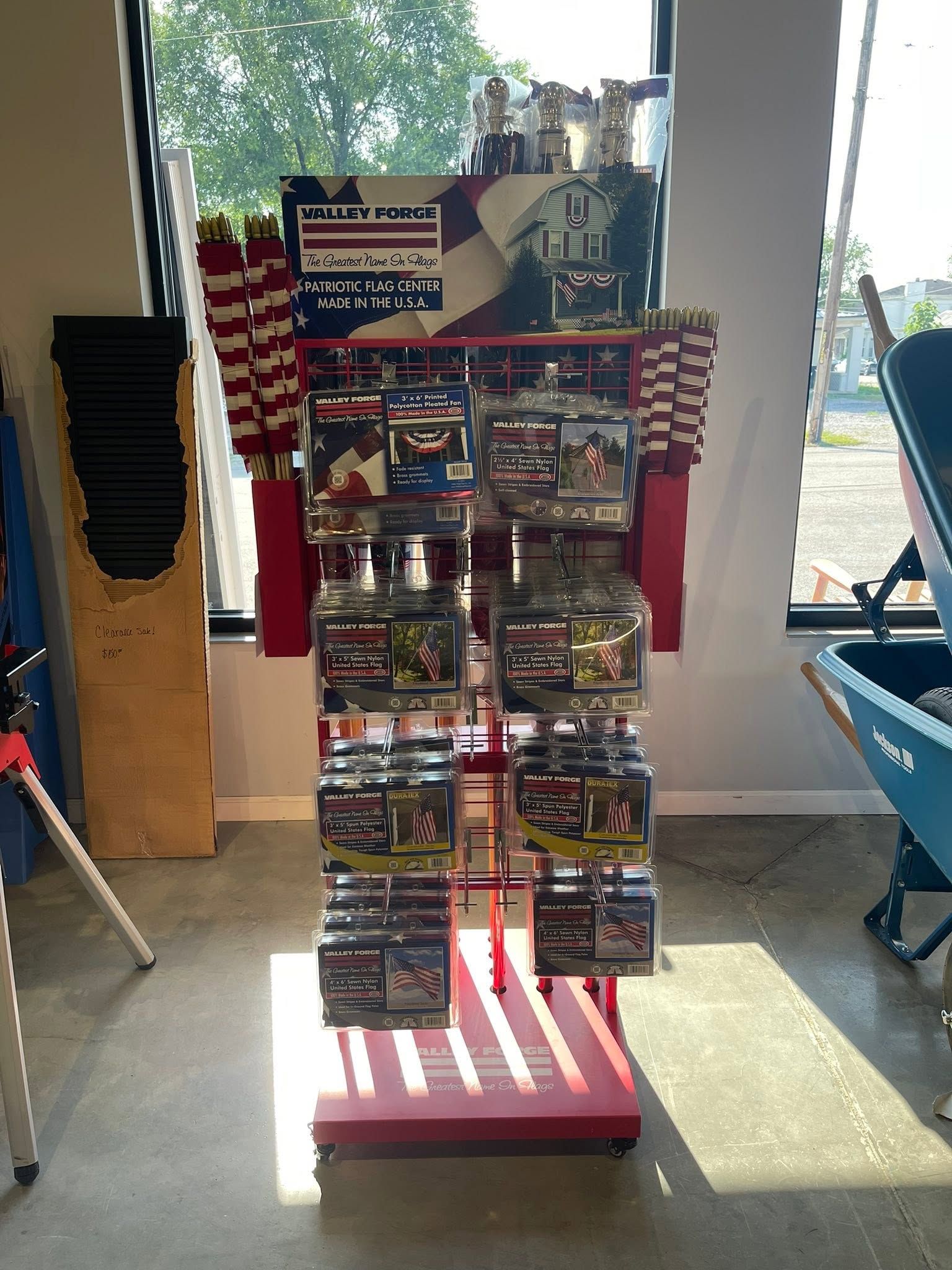 Greeting card display rack in a store entrance, with many cards and patriotic red, white, and blue decor.