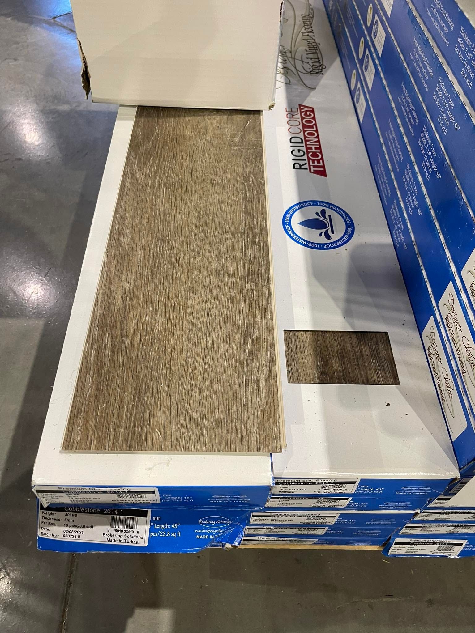 Store display with a narrow tan carpet runner on a white-and-blue platform, beside a blue sign.