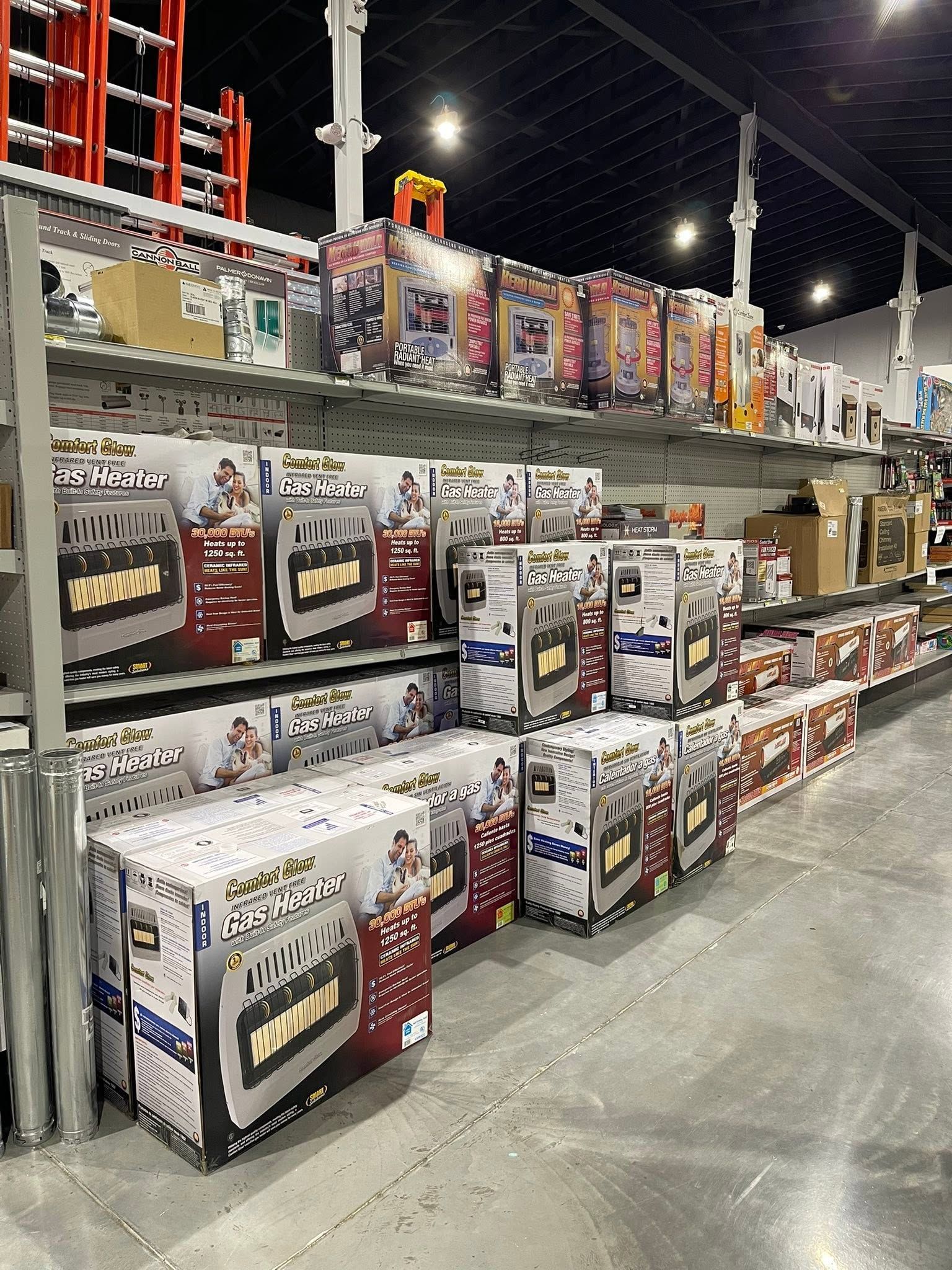 Warehouse store aisle with rows of boxed appliances and colorful products on metal shelves.