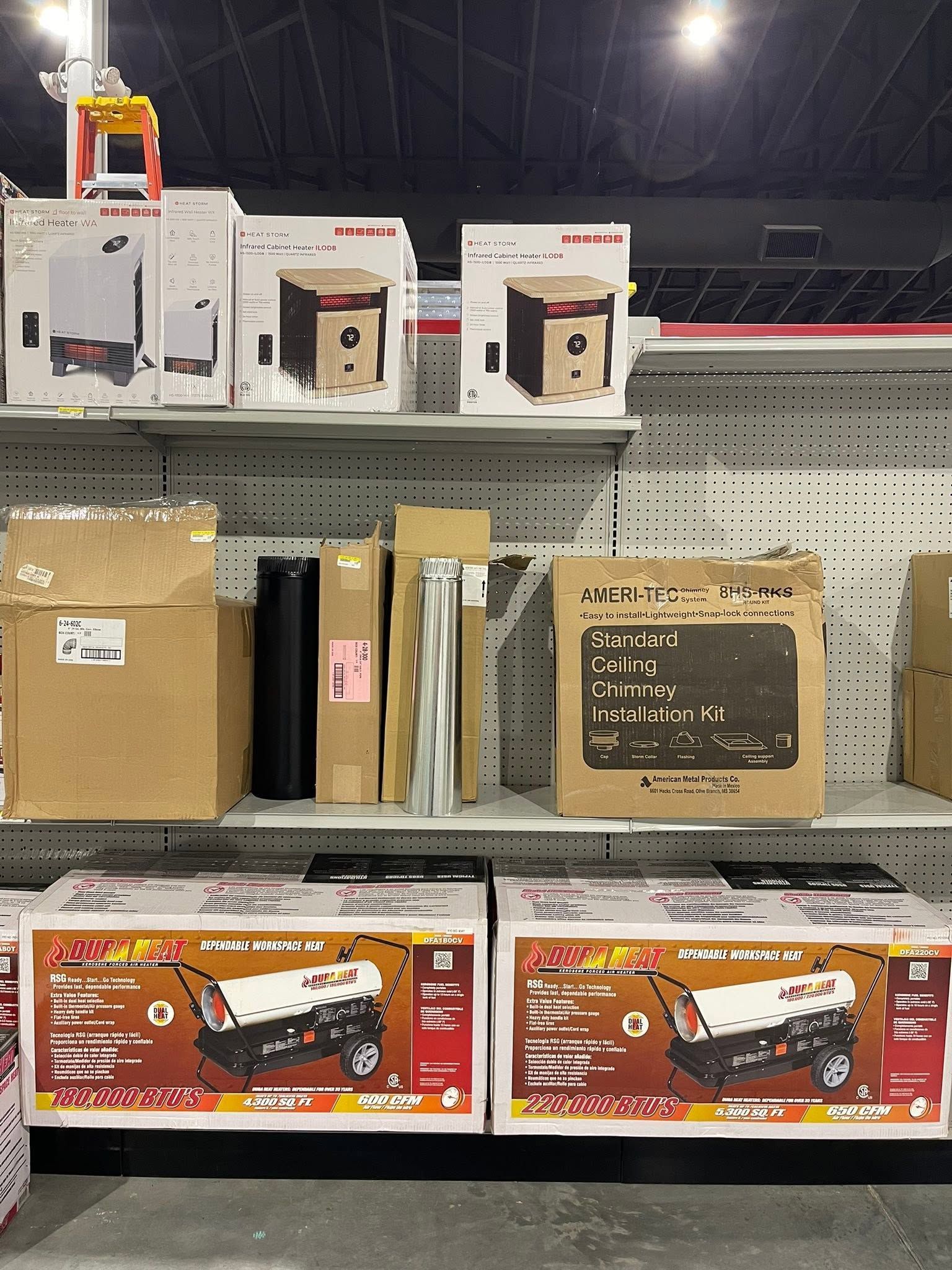 Store shelf with boxed tools and power equipment on display, including orange and white product packaging.