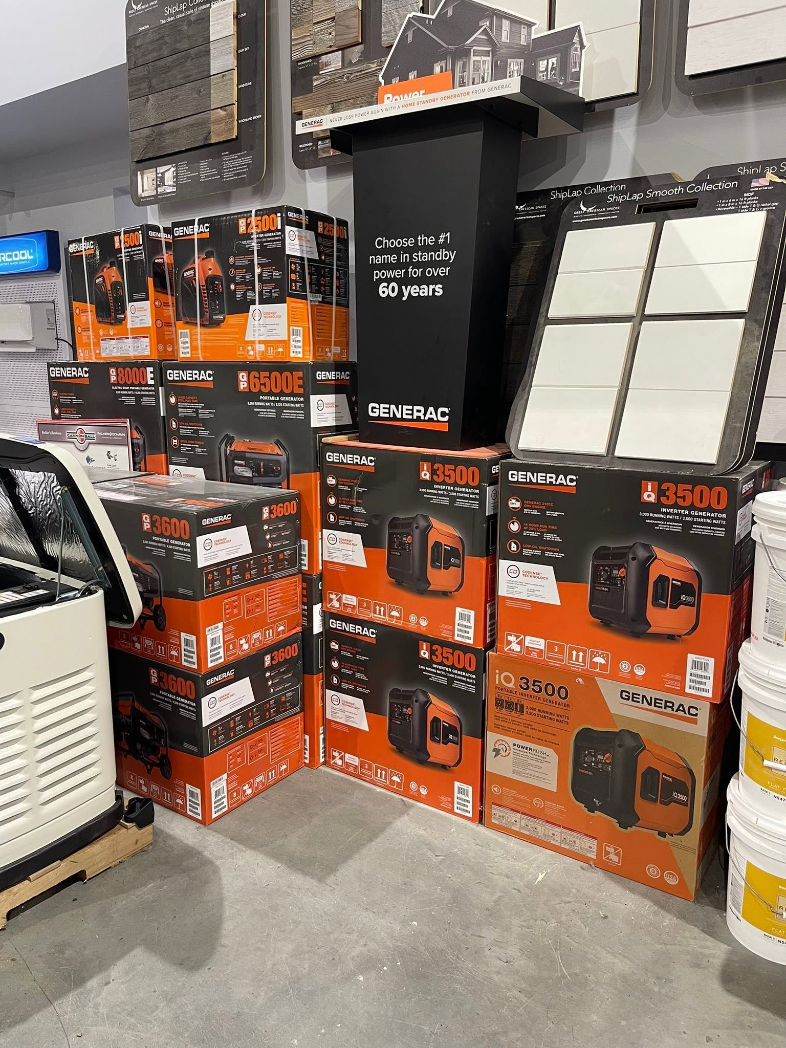 Stacks of black and orange boxed power equipment in a store aisle, beside a white appliance.