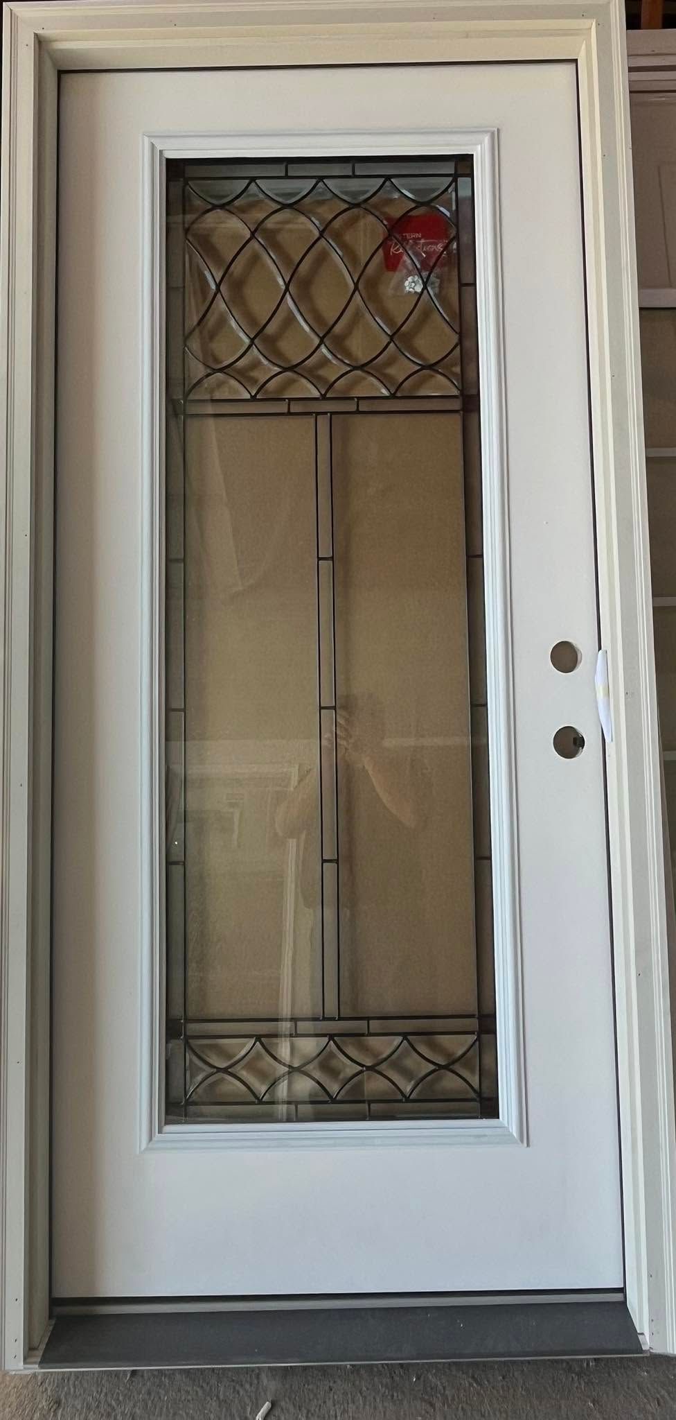 White front door with decorative glass panel and metal security grille, set in a beige exterior frame.