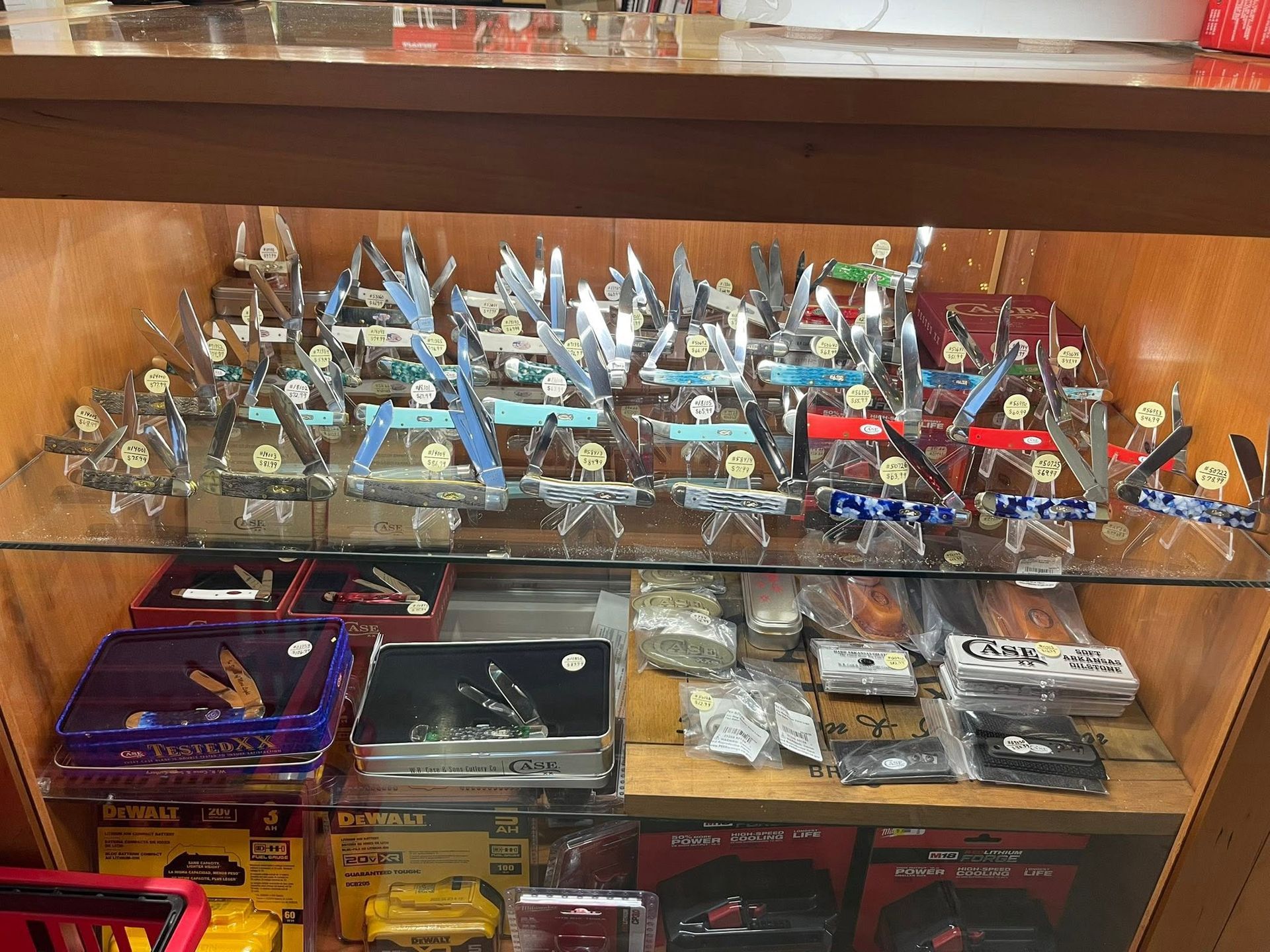 Glass display case filled with rows of small collectible toy vehicles and model cars in assorted colors