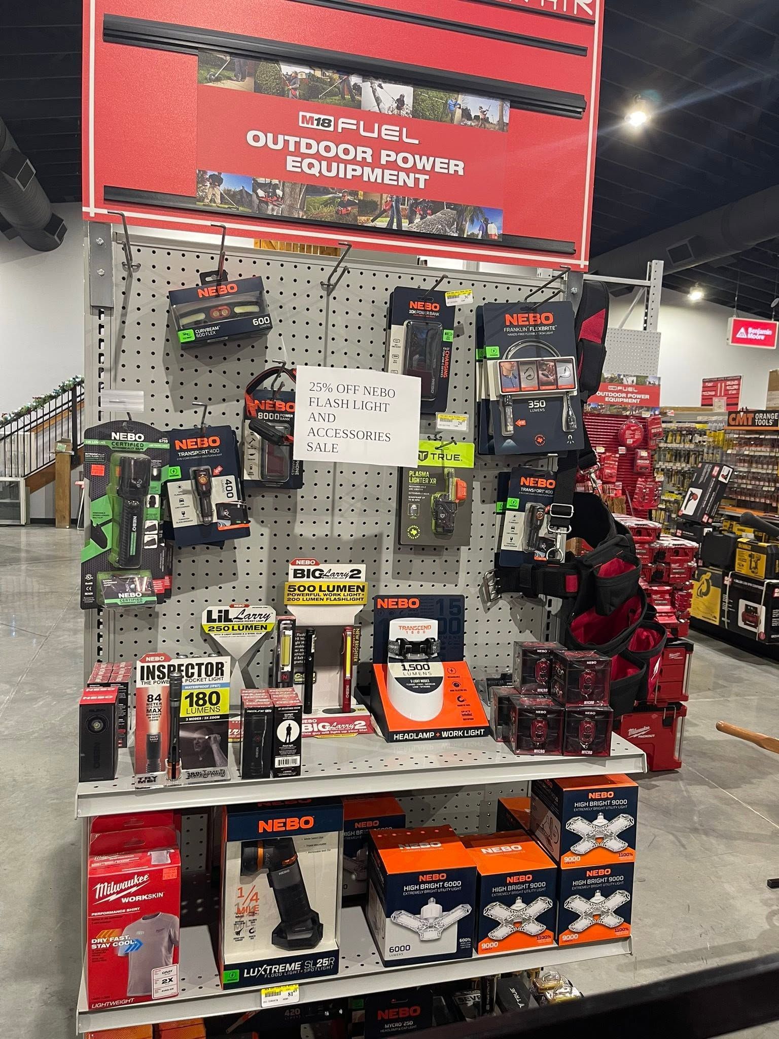 Power tool display at a hardware store, with drills, batteries, and boxed tools on shelves