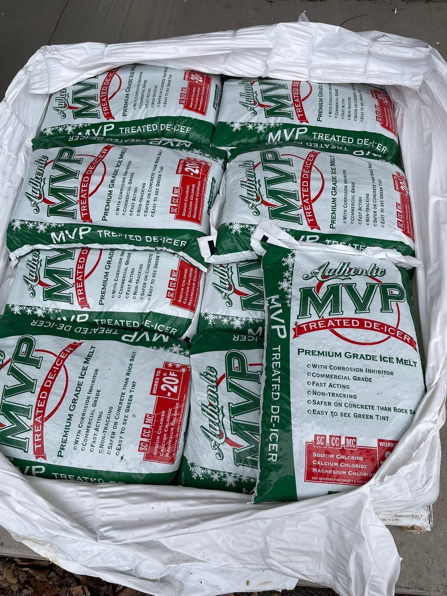 Open white sack filled with green-and-white packaged goods stacked neatly inside.