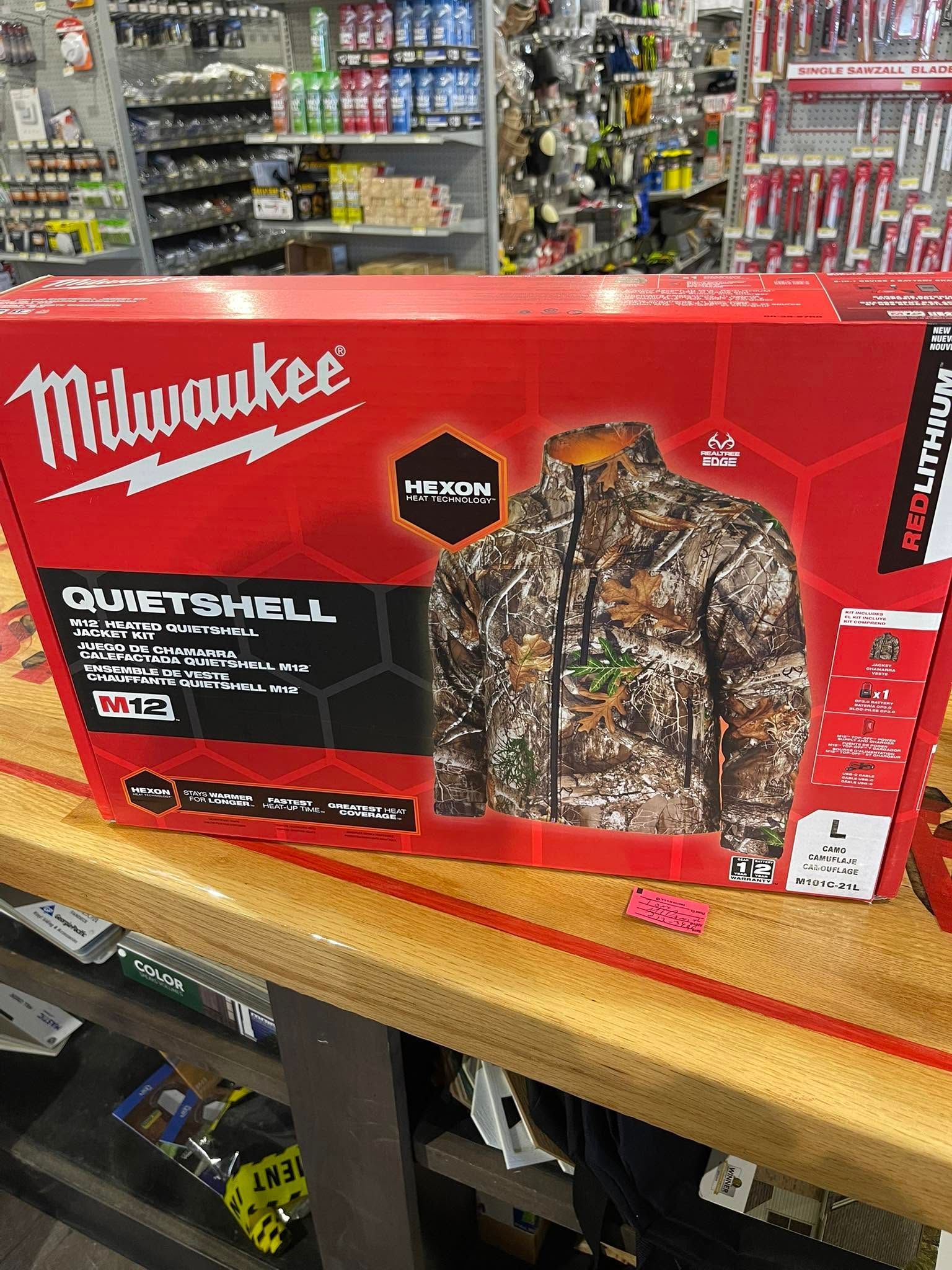 Milwaukee camouflage heated jacket box on a store shelf with tools and supplies in the background