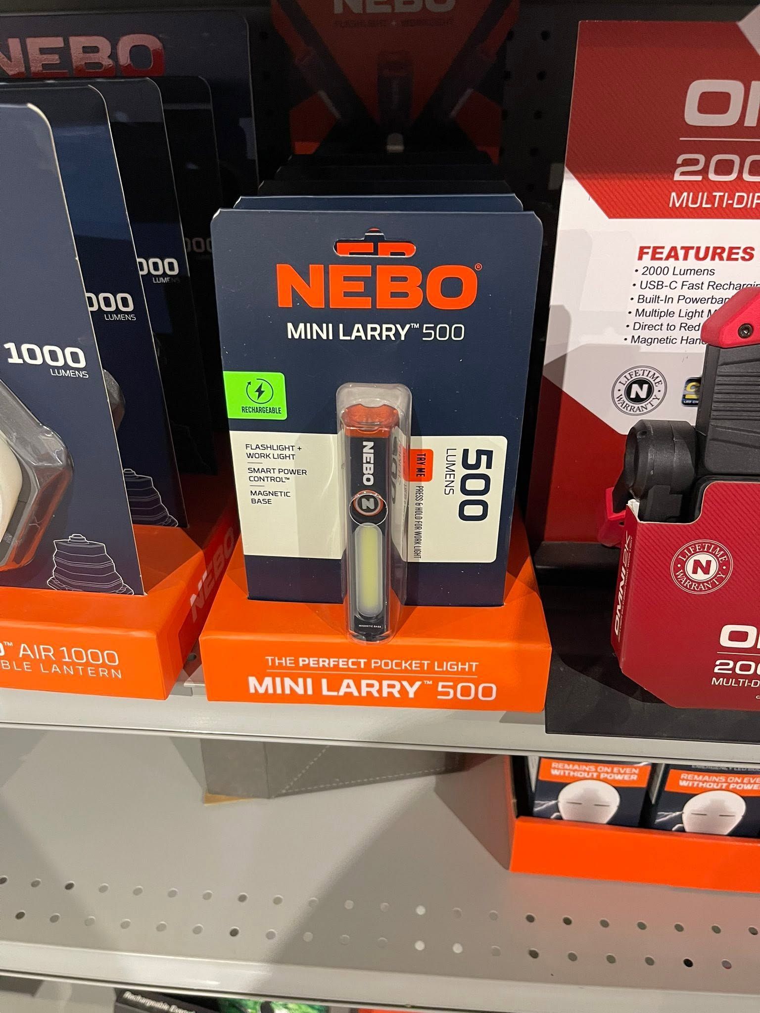 NEBO Mini Larry 500 flashlight in black and orange packaging on a store shelf