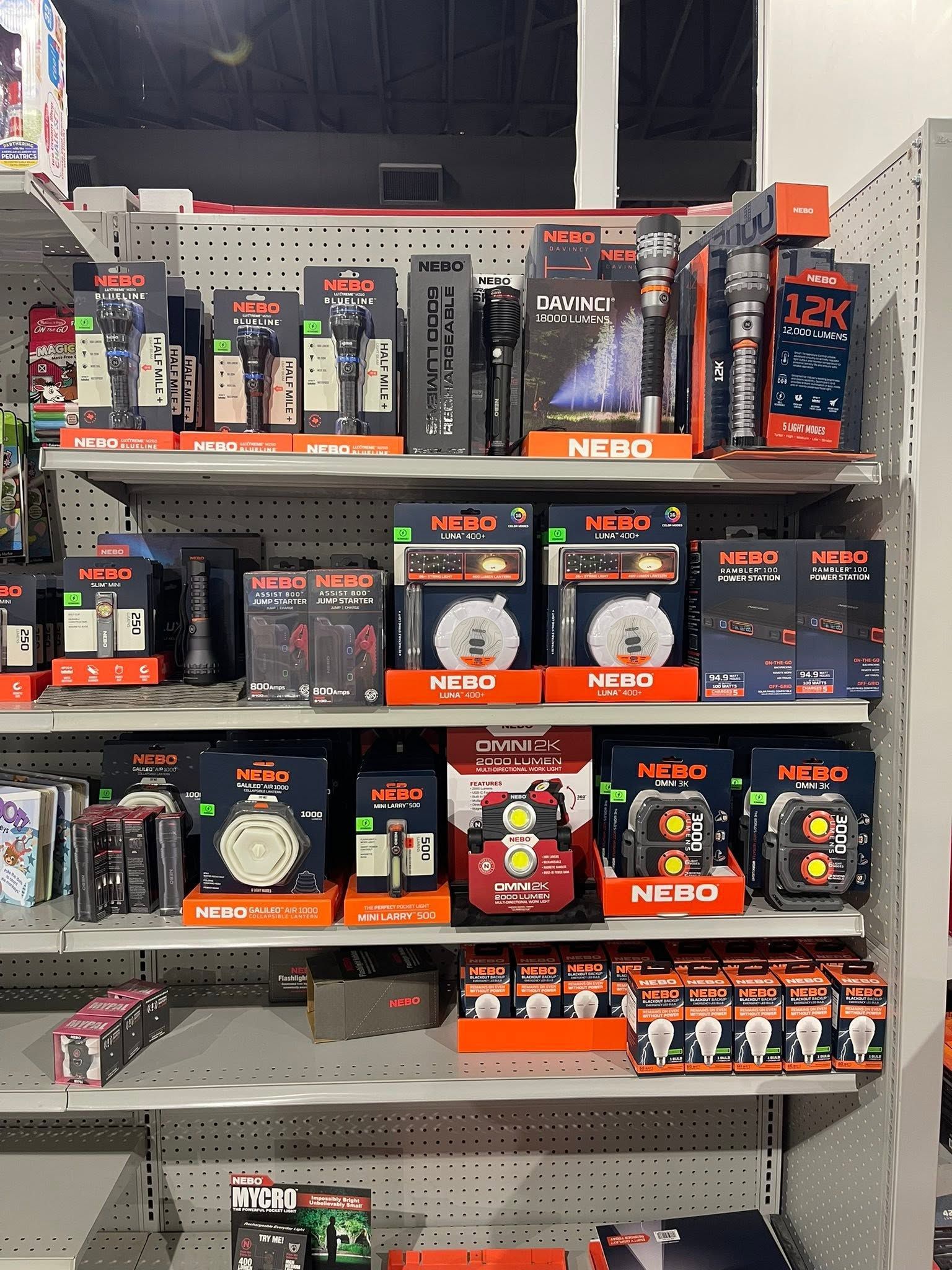 Store shelf stocked with assorted HUGO, NEDO, and other small boxed products in a retail aisle