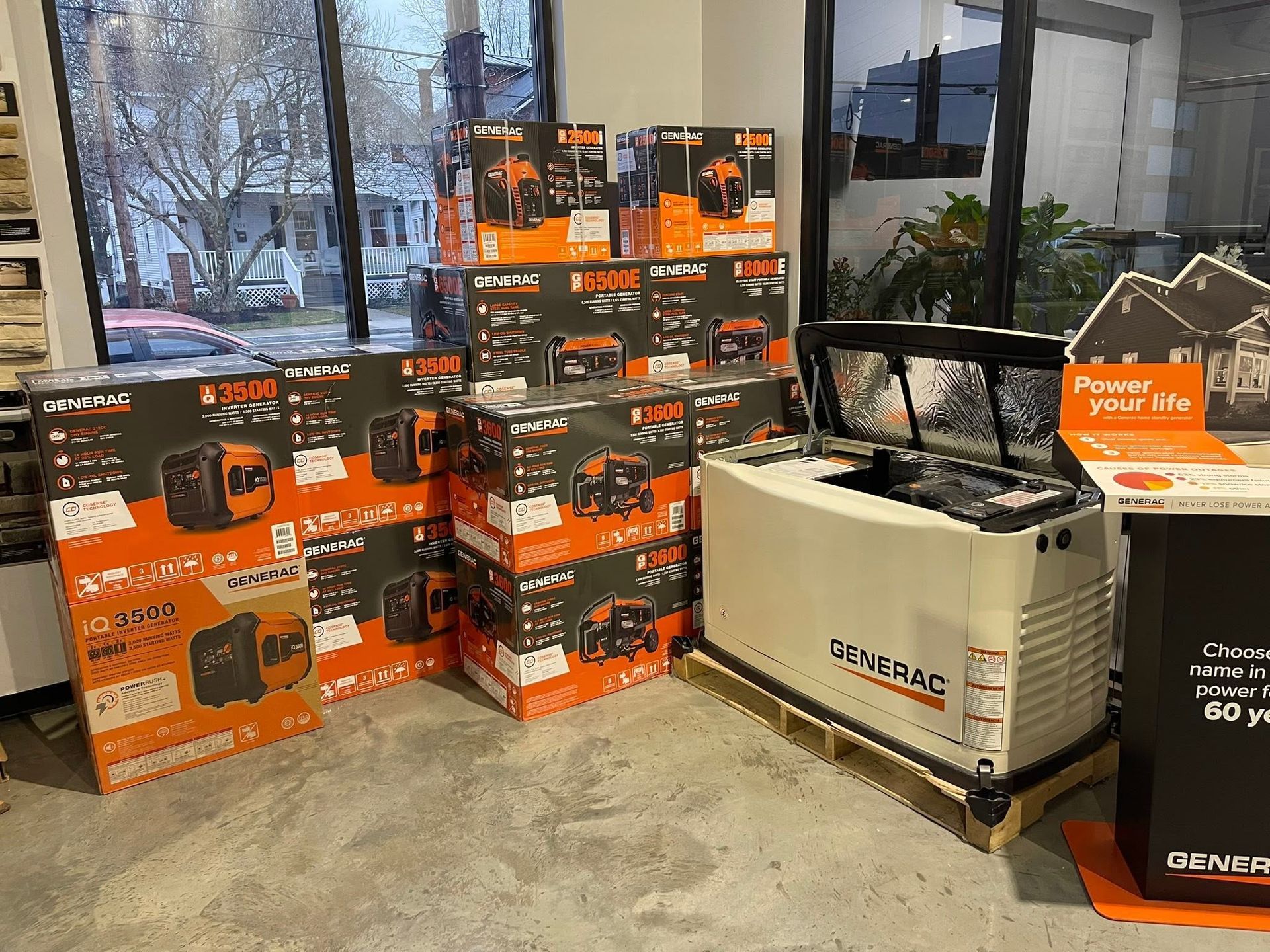 Stacks of orange generator boxes beside a beige generator in a store display