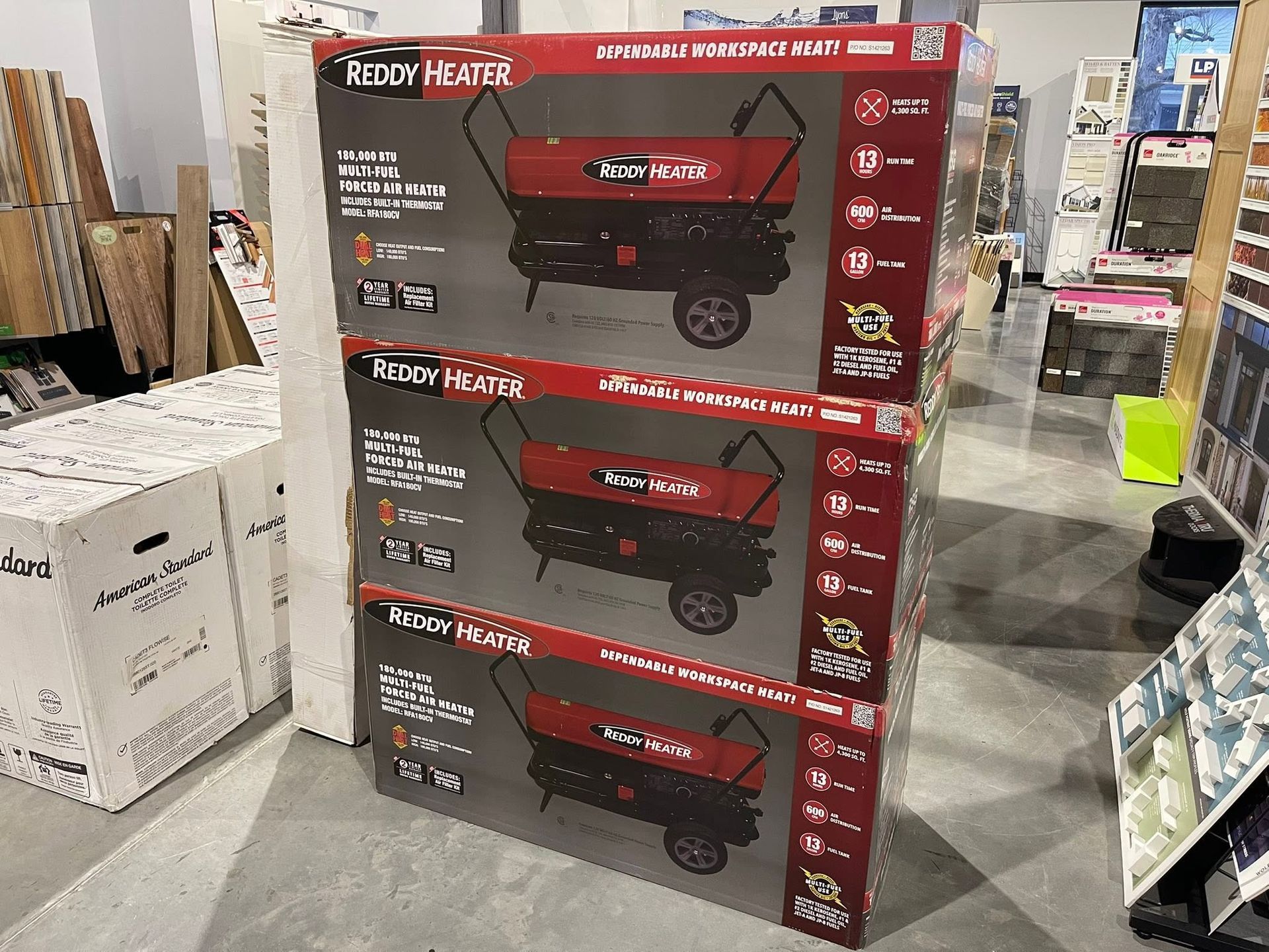 Stack of red yard carts in store aisle, boxed display with black wheels and handles.