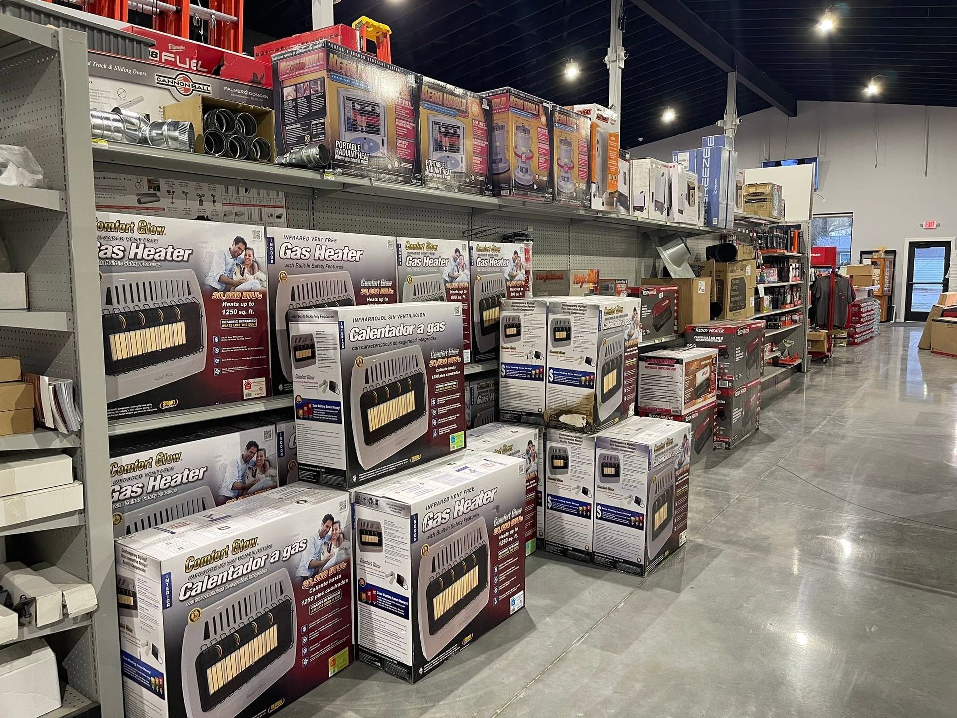 Store aisle with stacked boxes of grills and outdoor equipment under bright overhead lights