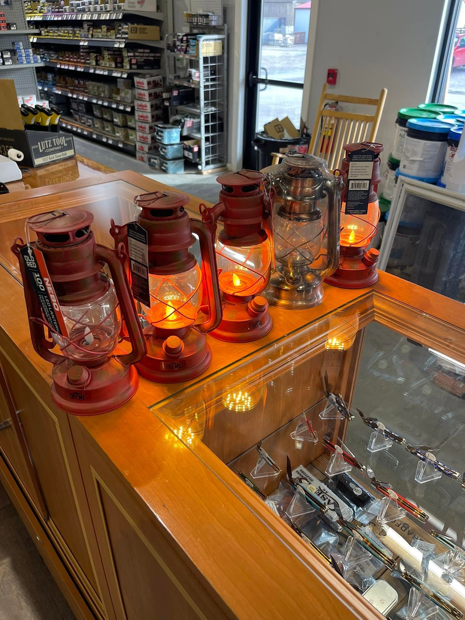 Red lantern-style lights glowing on a wooden counter in a store interior