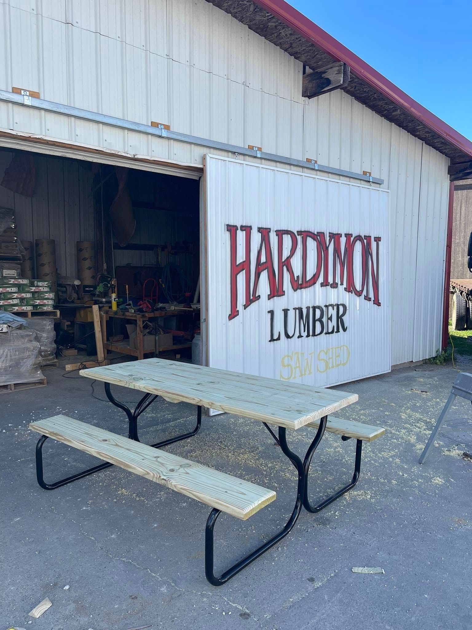 Picnic table outside Hardtoll Lumber building with open garage door