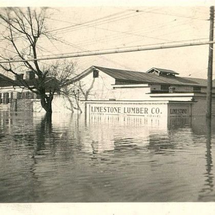 Flooded street beside Limestone Lumber Co. building with water covering the foreground