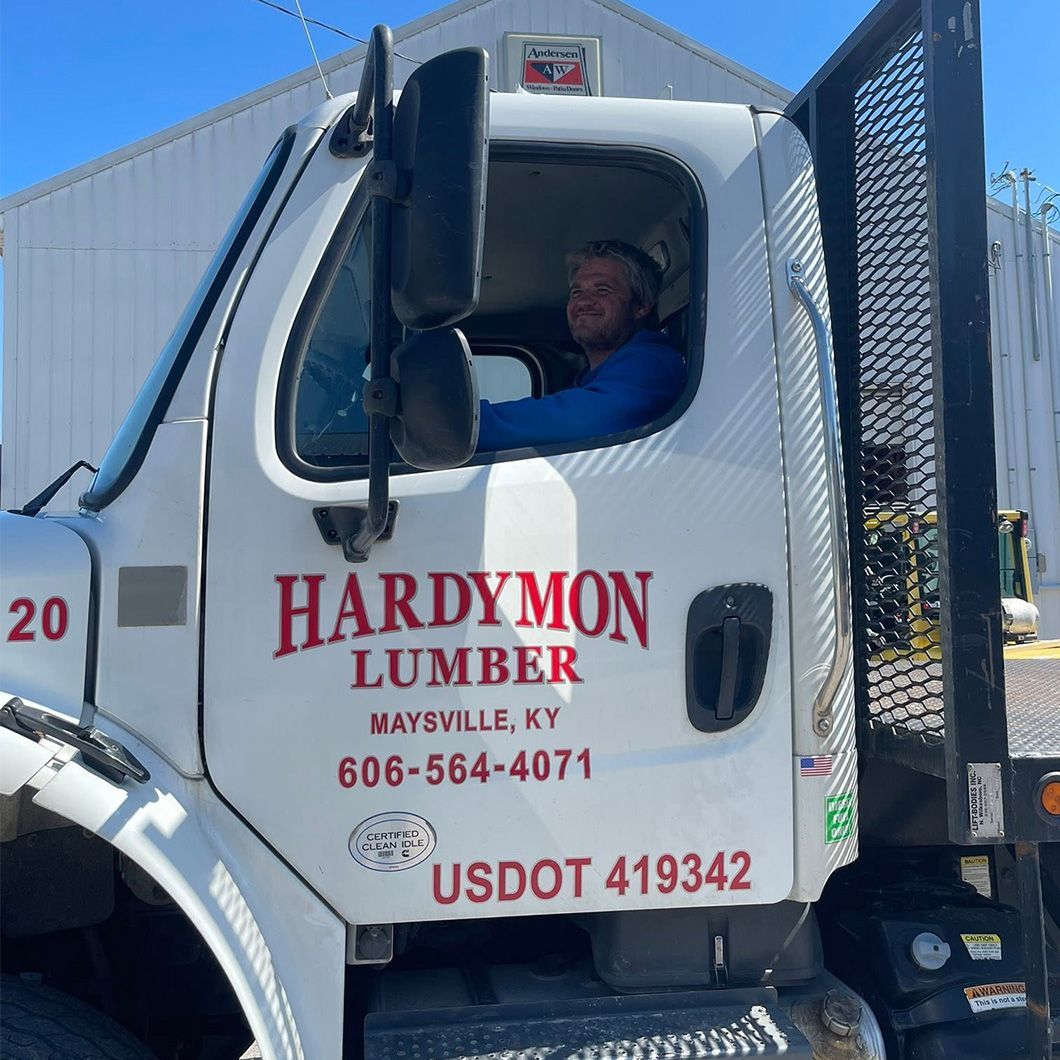 Hardymon Lumber truck cab with driver and company logo on white truck