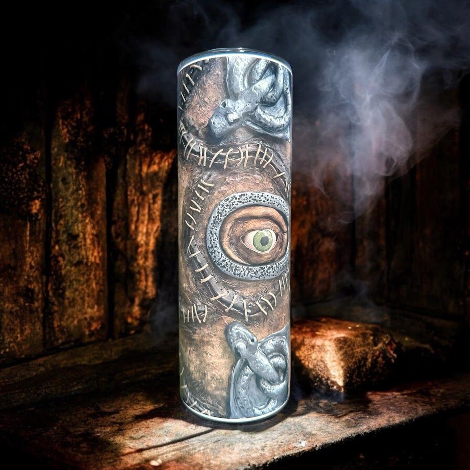 A cylindrical tumbler with a weathered, mystical design featuring an eye, set against smoky darkness.