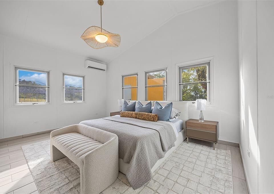 Primary bedroom with pendant light and large windows