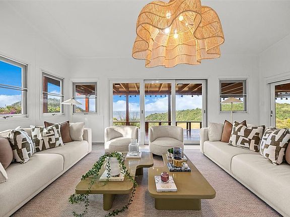 Living room with a rattan chandelier looking out to the deck