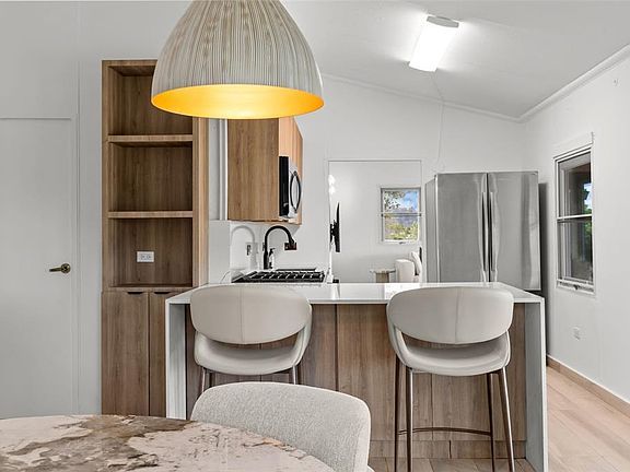 Kitchen island with bar stools and stainless appliances