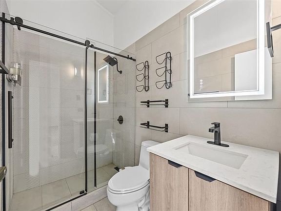 Bathroom with walk-in glass shower and tile
