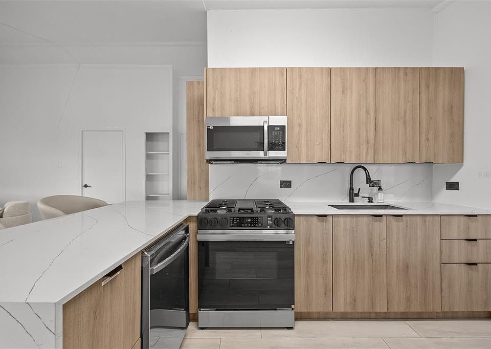Kitchen with gas range and light wood cabinets