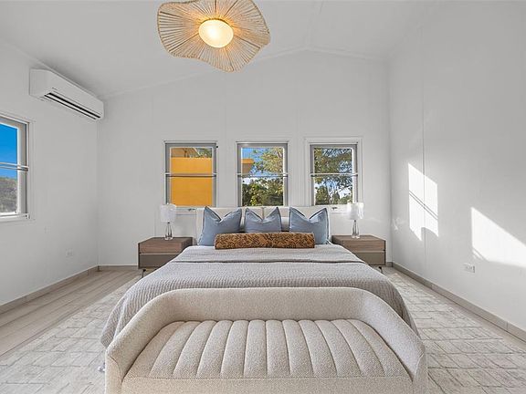 Bedroom with upholstered bed and rattan pendant light