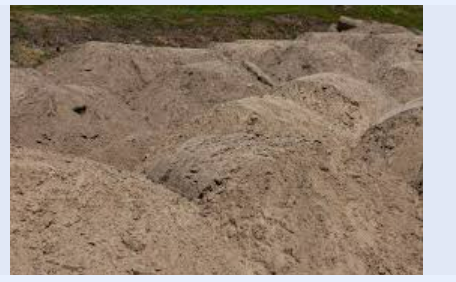 A pile of sand is sitting on top of each other in a field.