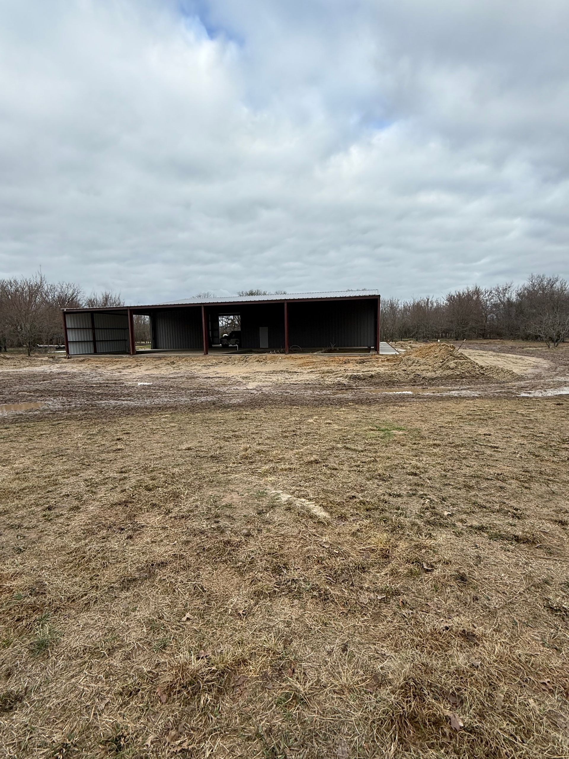 Abandoned shed in a barren field under a cloudy sky