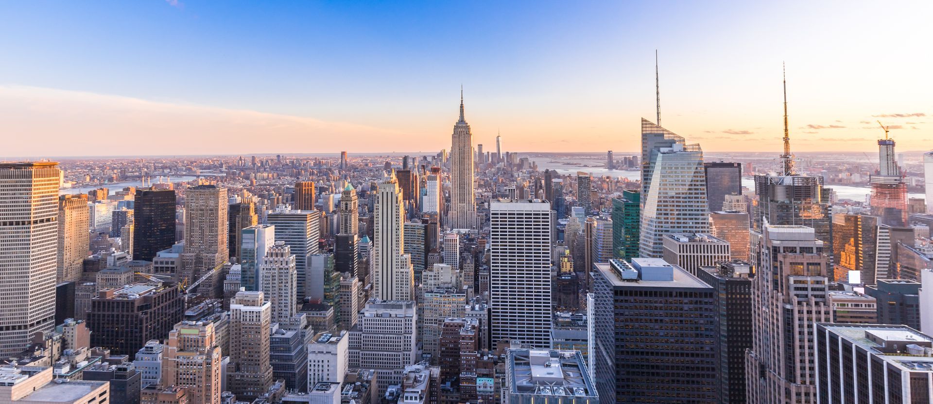 Skyline of Manhattan at sunset with dense skyscrapers and the Empire State Building