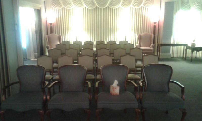 A row of chairs in a room with a tissue on each chair.