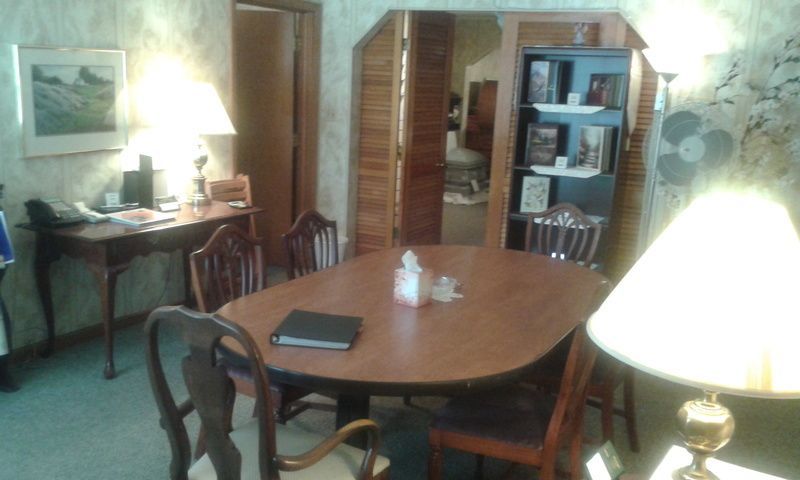A dining room with a table and chairs and a lamp