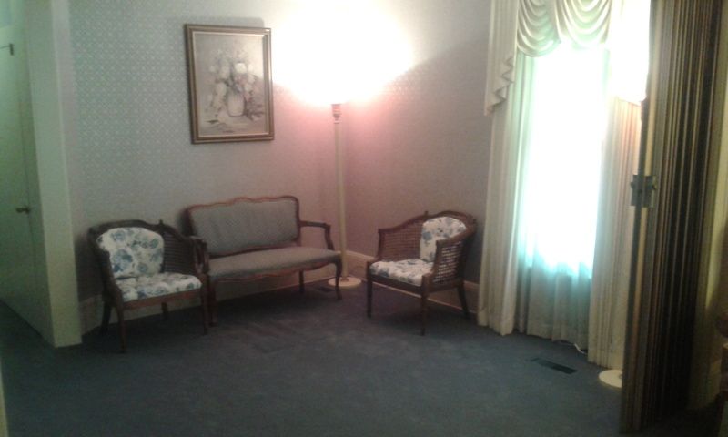 A living room with a couch , chairs and a lamp.