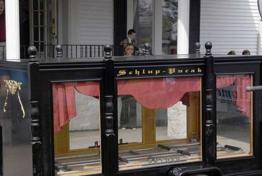A black carriage with a red curtain and a sign that says schlup-durak