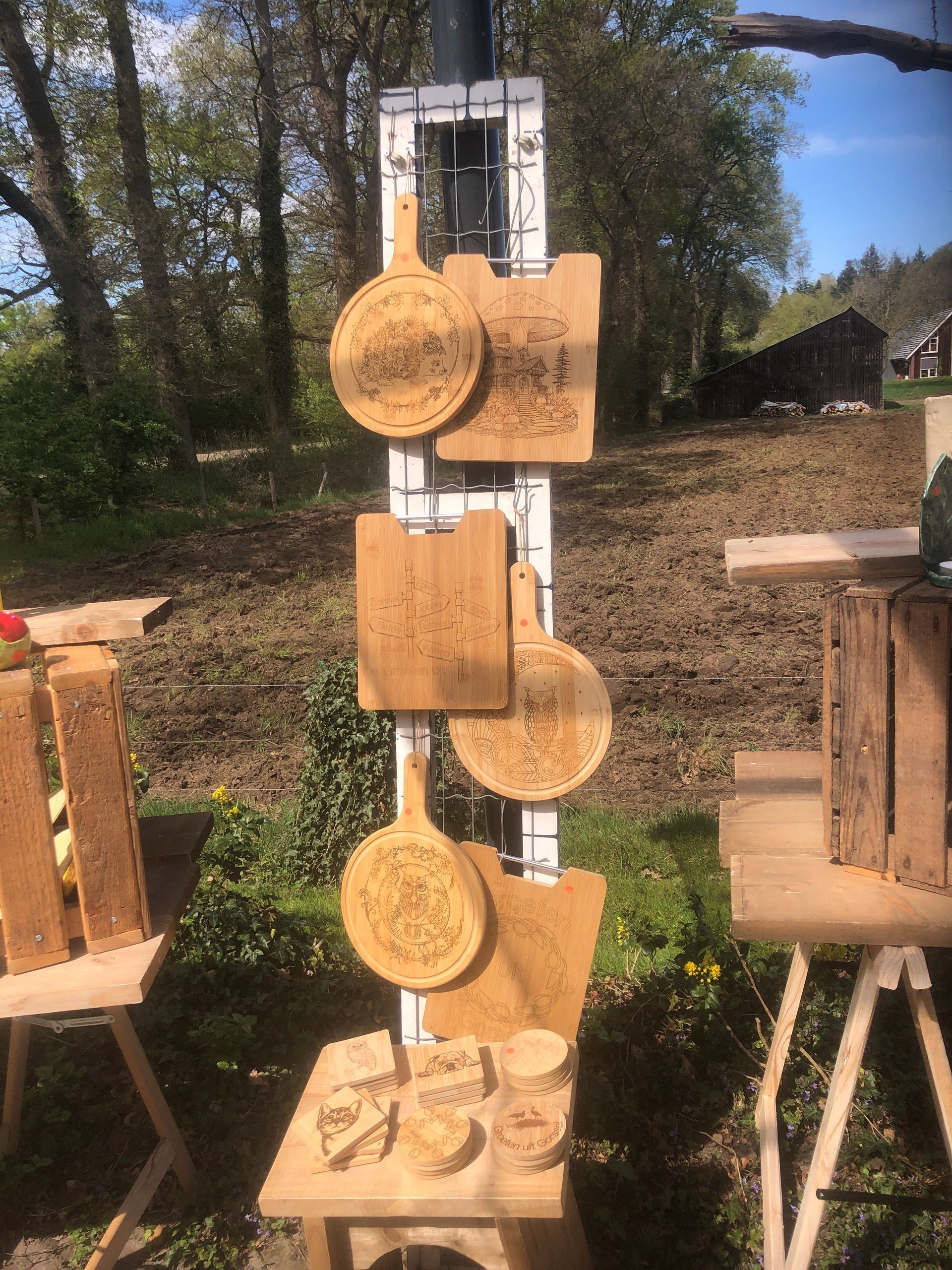 Houten snijplanken en decoratieve voorwerpen staan buiten tentoongesteld.