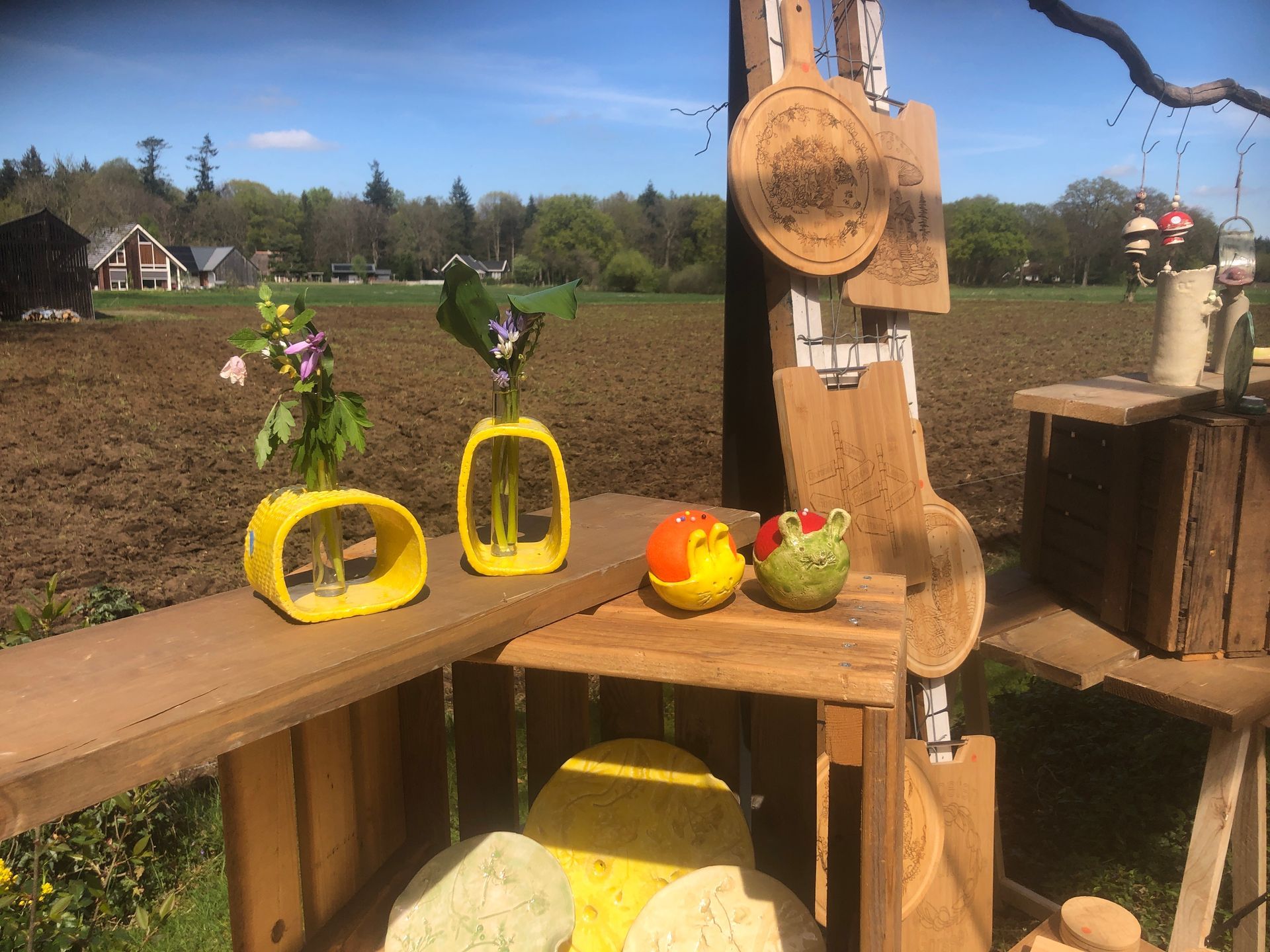 Houten display met vazen, snijplanken en decoratieve objecten in een landelijke setting.