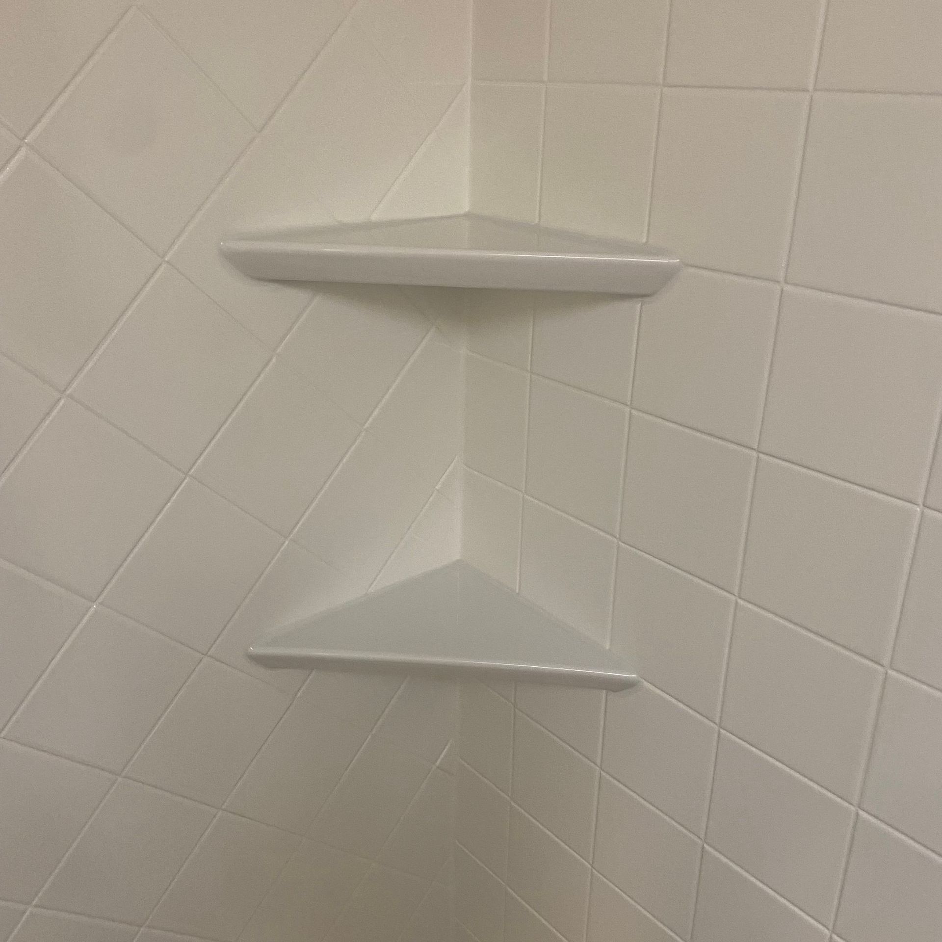 A close up of a stainless steel shower curtain rod on a white background.