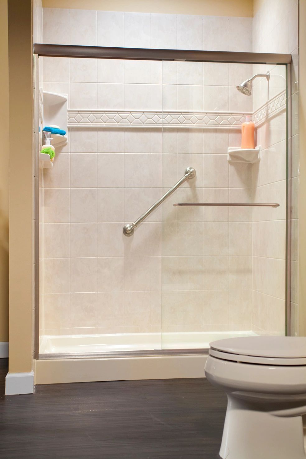 A bathroom with a toilet and a shower with a sliding glass door.