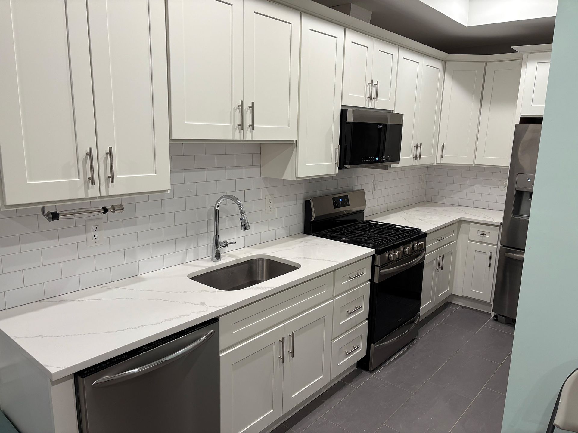 A kitchen with white cabinets and stainless steel appliances