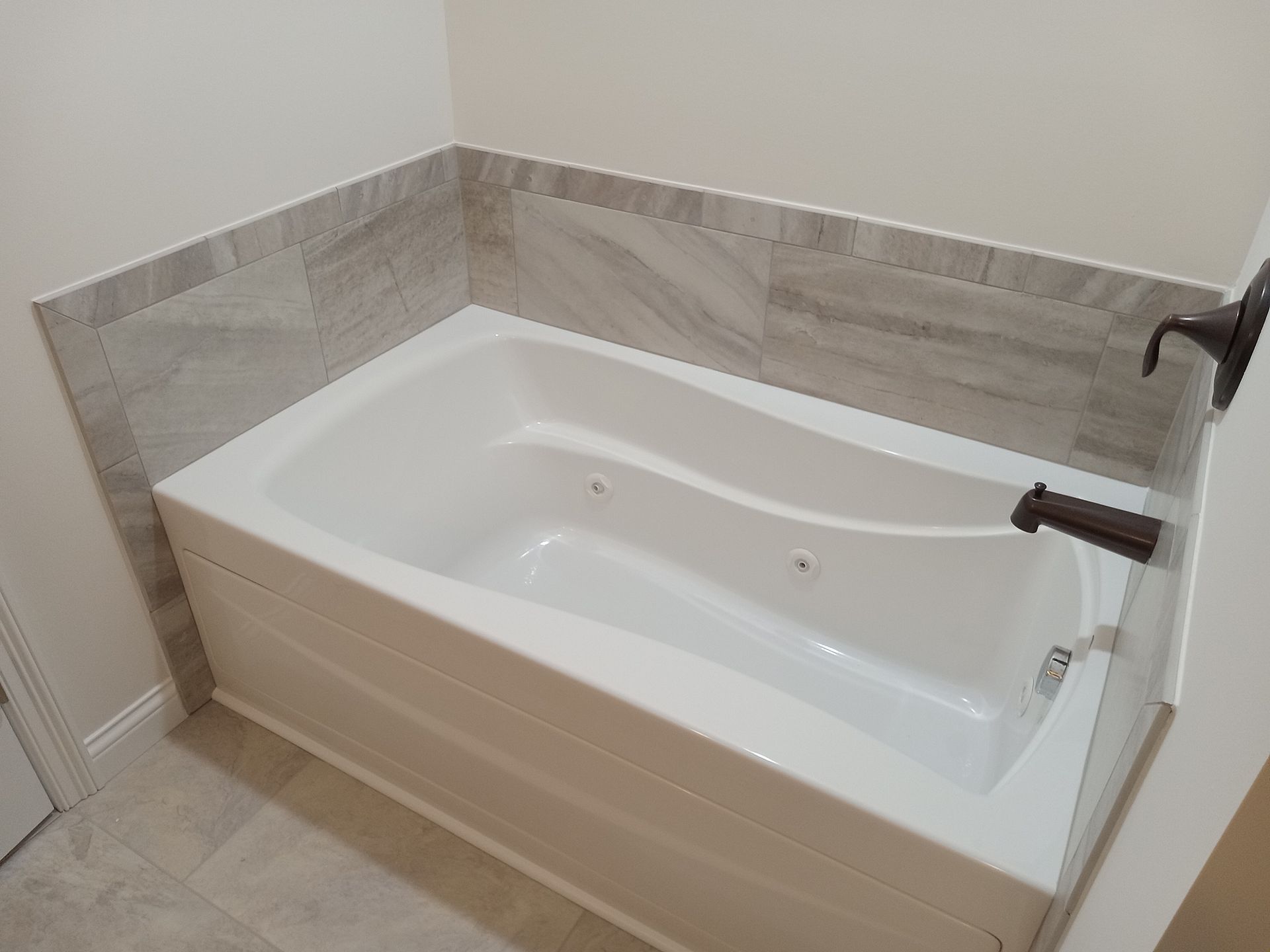 Freshly reglazed white bathtub in a modern bathroom with a smooth, glossy finish after refinishing.