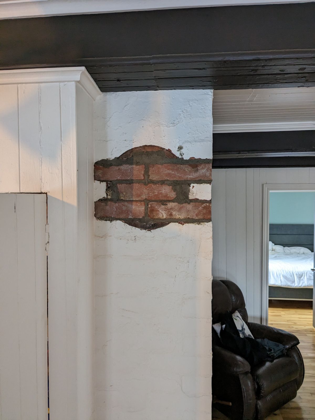 Un salon avec un mur de briques et une chaise