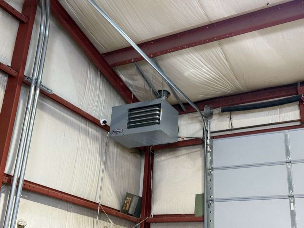 Interior of a metal warehouse with a hanging gray heater near the ceiling