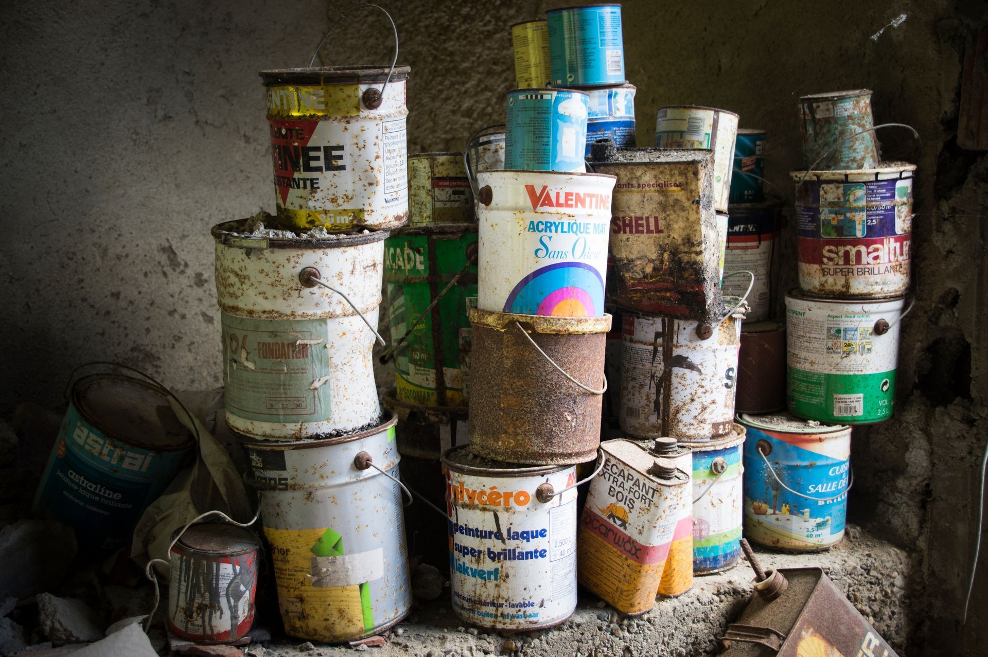 Un tas de pots de peinture sont empilés les uns sur les autres.