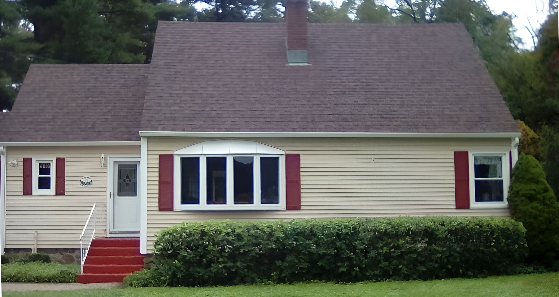 Hands hammering nails into tan house siding during exterior repair work