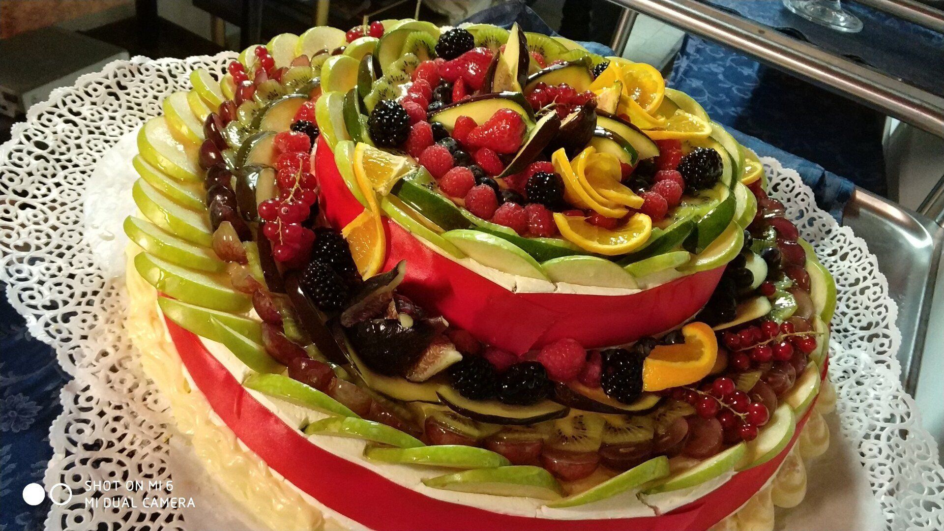 Una torta con della frutta sopra è appoggiata su un tavolo.